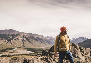 Männlicher Wanderer, der wegschaut, während er gegen Berge in Patagonien, Argentinien, steht - UUF20684