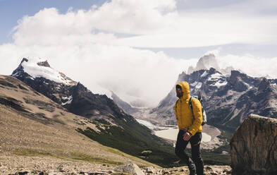 Man walking on mountain against cloudy sky, Patagonia, Argentina - UUF20728