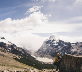 Mann schaut auf schneebedeckten Berg gegen den Himmel in Patagonien, Argentinien - UUF20729