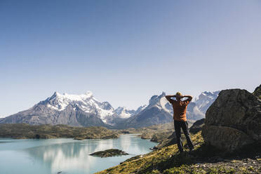 Man standing by lake against clear sky at Torres Del Paine National Park, Patagonia, Chile - UUF20741