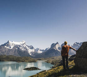 Männlicher Wanderer am See gegen den klaren Himmel im Torres Del Paine National Park, Patagonien, Chile - UUF20742