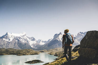 Mann mit Rucksack auf einem Berg gegen den klaren Himmel, Torres Del Paine National Park, Patagonien, Chile - UUF20747