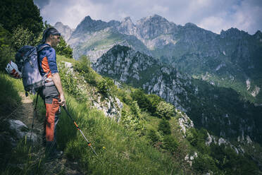 Hiker standing on mountain path enjoying view, Orobie, European Alps, Como, Italy - MCVF00478