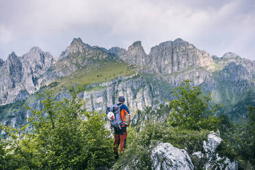 Hiker standing on mountain path enjoying view, Orobie, European Alps, Como, Italy - MCVF00480