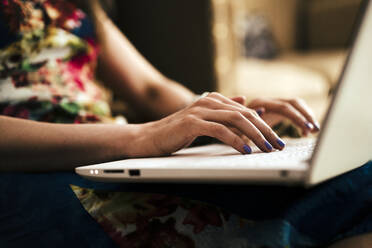 Close-up of woman's hands using laptop at home - EBBF00279