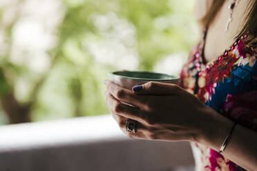 Close-up of woman's hands holding coffee cup - EBBF00288
