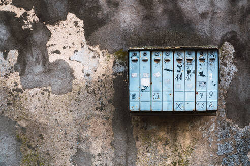 Verwitterter Briefkasten an einer bröckelnden Betonmauer in einer Stadtstraße - ADSF00061