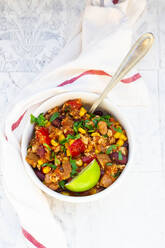 Schale mit vegetarischem Chili mit Tofu, Mais, Kidney- und Pinto-Bohnen, Koriander und Limette - LVF08945