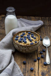 Milchflasche und Schüssel mit Müsli mit Blaubeeren und Quinoa - LVF08946