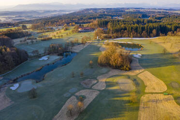 Deutschland, Bayern, Wolfratshausen, Drohnenansicht eines ländlichen Golfplatzes in der Dämmerung - LHF00797