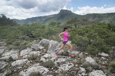 Ein Mädchen mit rosa T-Shirt Trail Running auf einem hohen felsigen Oberfläche - CAVF86204
