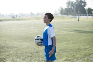 Jugendlicher Fußballspieler hält den Ball und ist bereit für einen Einwurf - CAVF86221