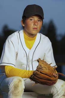 Porträt eines Jungen in weißer Baseball-Uniform mit seinem Handschuh - CAVF86227