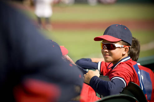Junge mit Sonnenbrille und Grinsen in Baseball-Uniform - CAVF86231