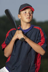 Porträt eines Baseballspielers, der seinen Schläger hält und eine Aufwärmjacke trägt - CAVF86236