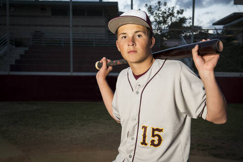 Porträt eines High-School-Baseballspielers, der seinen Schläger hält - CAVF86257