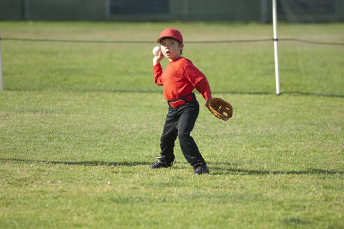 Ein Junge wirft einen Baseball auf dem TBall-Feld - CAVF86263