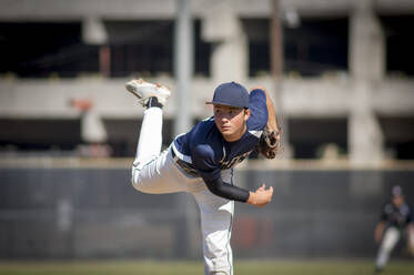 Teenager-Baseballspieler Pitcher in blauer Uniform auf dem Hügel - CAVF86273