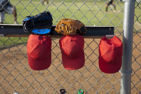 Hüte und Handschuhe hängen in einem TBall-Unterstand - CAVF86275