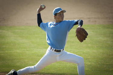 Pitcher in hellblau-weißem Trikot beim Aufwärmen auf dem Hügel - CAVF86280