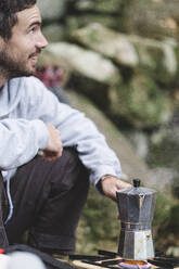 Ein Mann bereitet im Freien Kaffee zu - CAVF86346