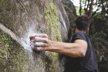 Nahaufnahme eines Bergsteigers, der seine Hand auf einen Felsen legt - CAVF86353
