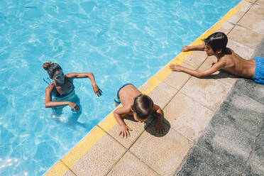 Family playing in a pool - CAVF86365