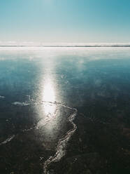 Sonnenschein, der an einem Wintertag auf das Eis eines zugefrorenen kanadischen Sees trifft. - CAVF86381