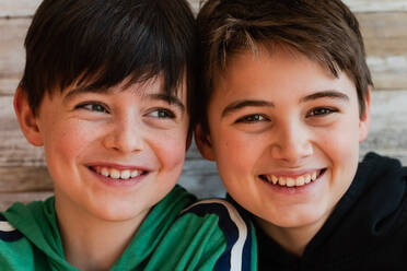 Close up of two smiling boys with their heads close together. - CAVF86395