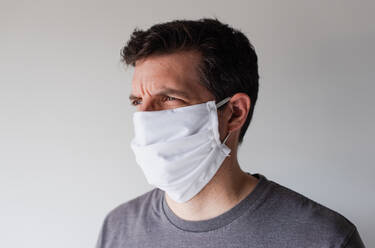 Man wearing homemade cloth face mask during Covid 19 pandemic. - CAVF86426