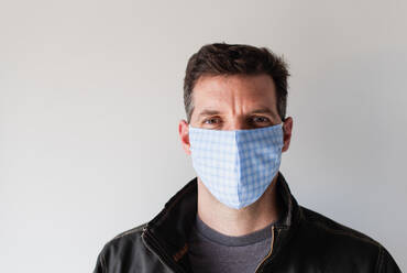Ein Mann trägt während der Pandemie Covid 19 eine selbstgebastelte Gesichtsmaske aus Stoff. - CAVF86429