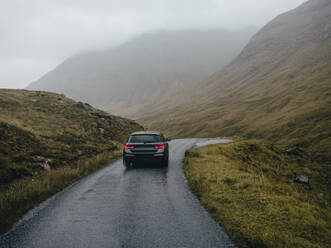 Car driving on road through Glen Etive - CAVF86444