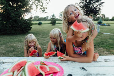 Alberne Kinder, die im Sommer draußen Wassermelone essen - CAVF86498