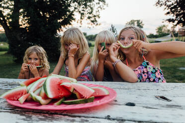 Kleine Kinder, die im Sommer lachend draußen Wassermelone essen - CAVF86499