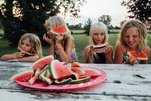 Geschwister haben Spaß beim Essen von Wassermelone im Freien im Sommer - CAVF86500
