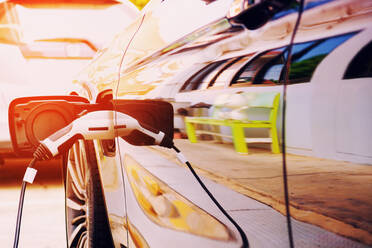 Close-Up Of Reflection On Charging Car At Gas Station - EYF08964