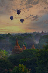 Myanmar, Region Mandalay, Bagan, Silhouetten von Heißluftballons, die bei stimmungsvoller Morgendämmerung über alte Tempel fliegen - TOVF00201