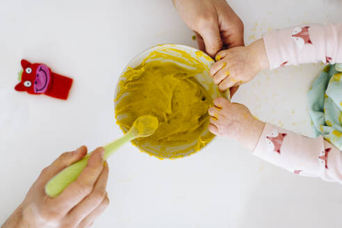 Vater mit Löffel und kleines Mädchen berühren Schüssel mit Babynahrung - SODF00801