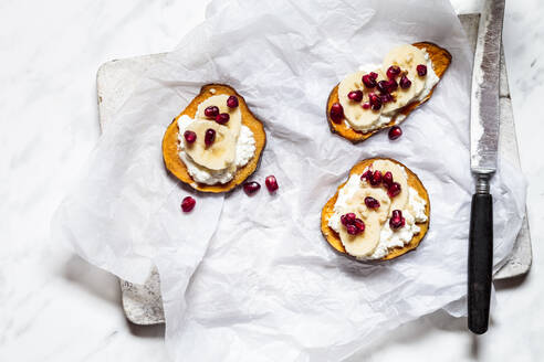 Toasted slices of sweet potato with cottage cheese, banana and pomegranate seeds - SBDF04267