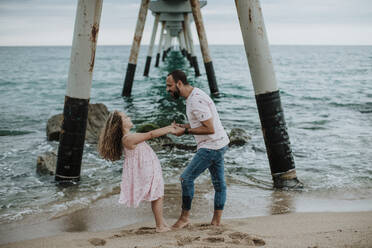 Daughter and father enjoying vacation at beach - GMLF00326