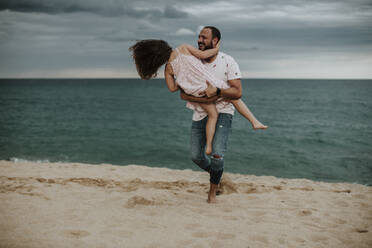 Glücklicher Vater mit Tochter am Strand - GMLF00335