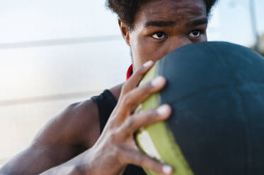 Nahaufnahme eines jungen Mannes, der einen Basketball hält - JMPF00015