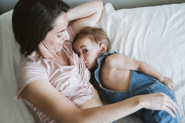 Mother breast feeding baby girl on bed - EBBF00339