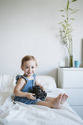 Kleines Mädchen hält Kamera zu Hause - EBBF00347