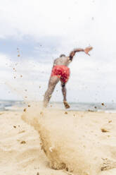 Sportlicher Mann läuft am Strand - OCMF01404