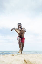 Sportlicher Mann läuft am Strand - OCMF01407