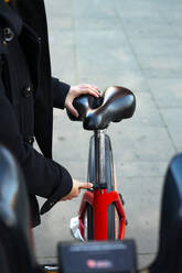 Frau stellt den Fahrradsattel ein. - CAVF86603