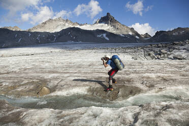 Man takes pictures on Snowbird Glacier, Talkeetna Mountains, Alaska - CAVF86630