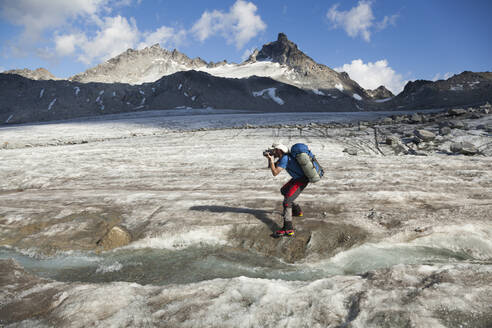 Mann macht Fotos auf dem Snowbird Glacier, Talkeetna Mountains, Alaska - CAVF86630