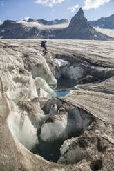 Man at meltwater pond, Snowbird Glacier, Talkeetna Mountains, Alaska - CAVF86635